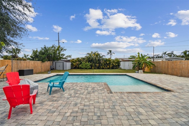 view of swimming pool with a patio area and a storage shed