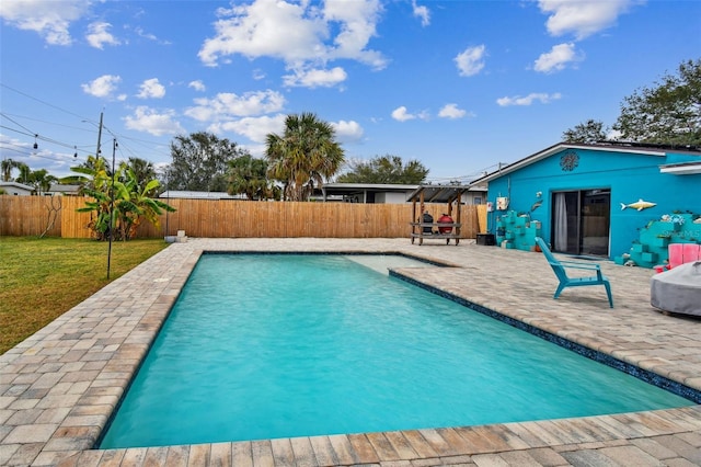 view of swimming pool featuring a yard and a patio area