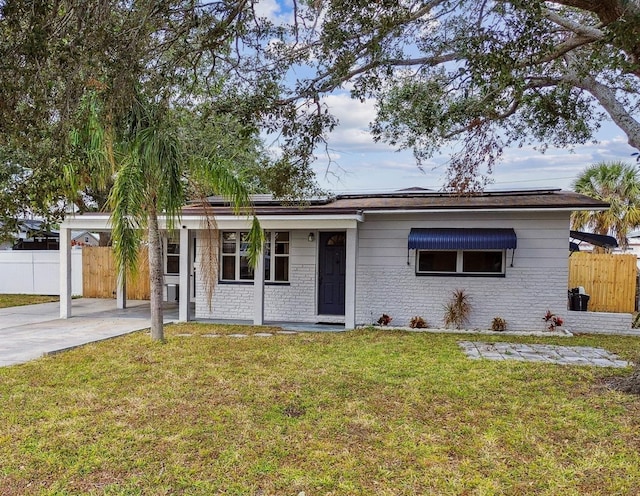 ranch-style house featuring a carport, brick siding, and a front lawn