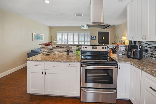 kitchen featuring white cabinets, kitchen peninsula, stainless steel electric range, light stone countertops, and island range hood