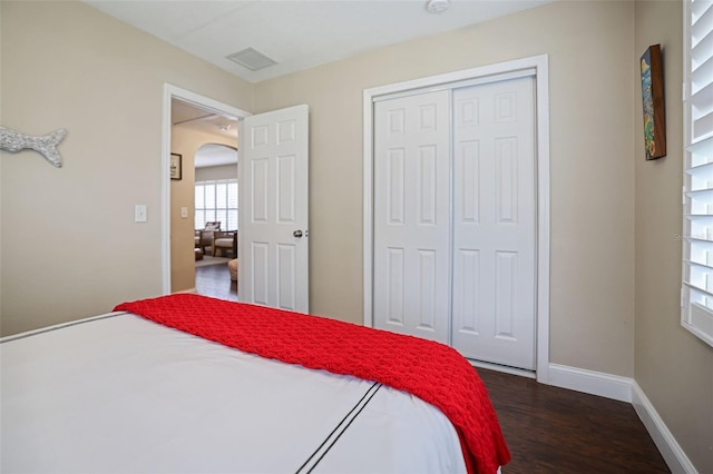 bedroom with a closet and dark wood-type flooring