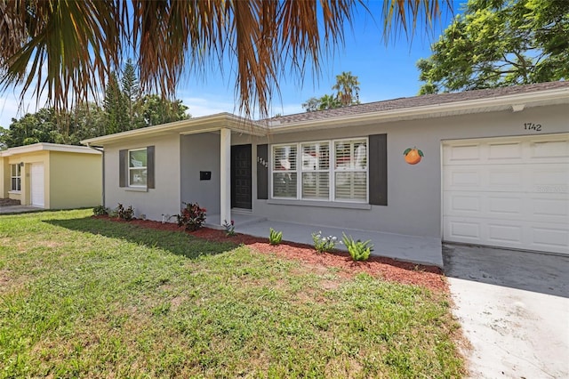 ranch-style house featuring a front lawn and a garage