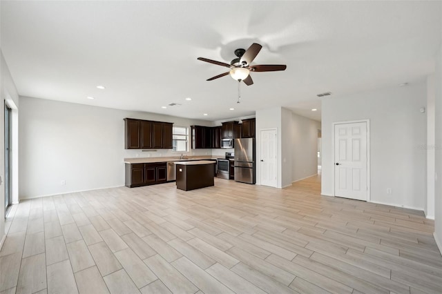 kitchen with light hardwood / wood-style flooring, a center island, stainless steel appliances, ceiling fan, and dark brown cabinets