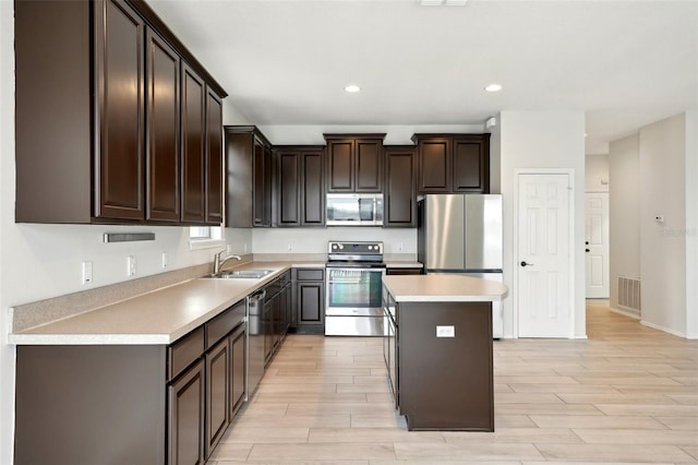 kitchen with sink, stainless steel appliances, a kitchen island, and dark brown cabinetry