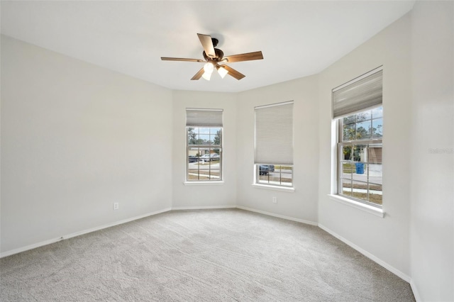 carpeted spare room with ceiling fan