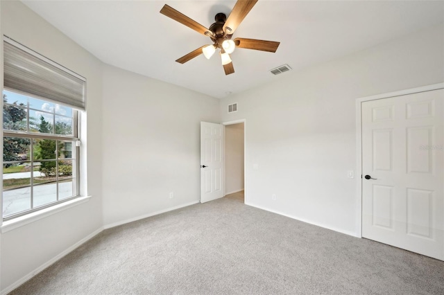 spare room with ceiling fan, a healthy amount of sunlight, and carpet