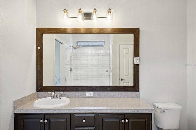 bathroom featuring toilet, a shower, and vanity