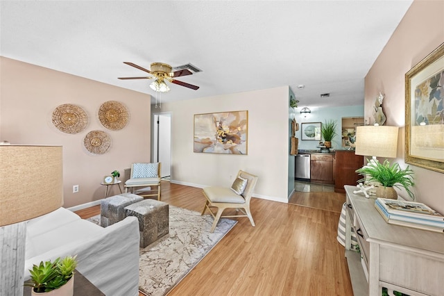 living room featuring ceiling fan and light hardwood / wood-style flooring