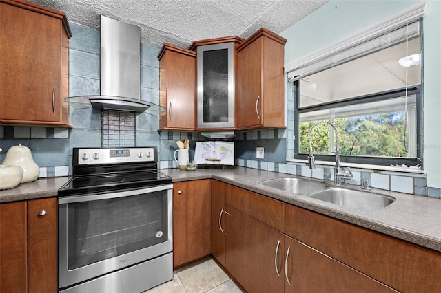 kitchen featuring light tile patterned floors, a textured ceiling, stainless steel electric range oven, wall chimney exhaust hood, and sink