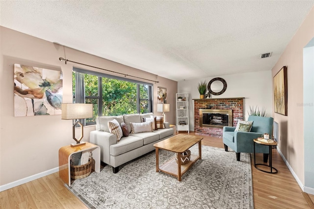 living room with a textured ceiling and light hardwood / wood-style floors