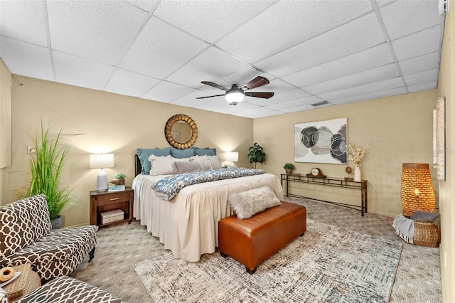 carpeted bedroom with a drop ceiling and ceiling fan