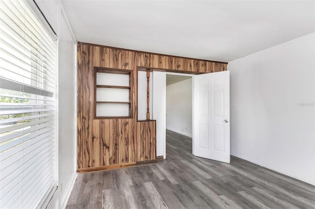 empty room featuring wood walls and dark hardwood / wood-style floors