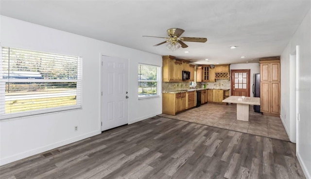 kitchen with dark hardwood / wood-style floors, ceiling fan, black appliances, and decorative backsplash