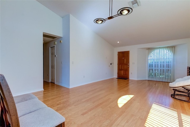 living room with high vaulted ceiling and light wood-type flooring