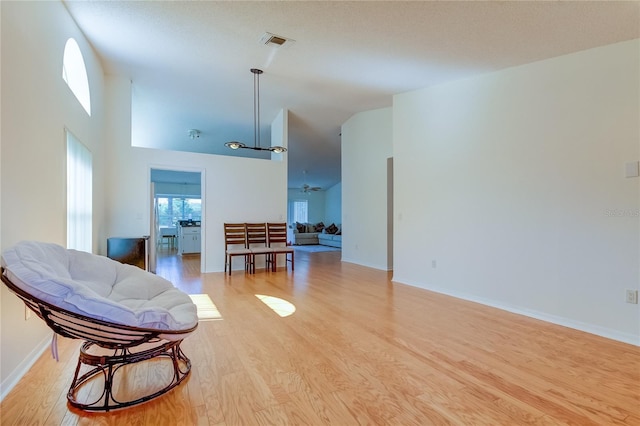 interior space featuring light hardwood / wood-style floors, ceiling fan, and high vaulted ceiling