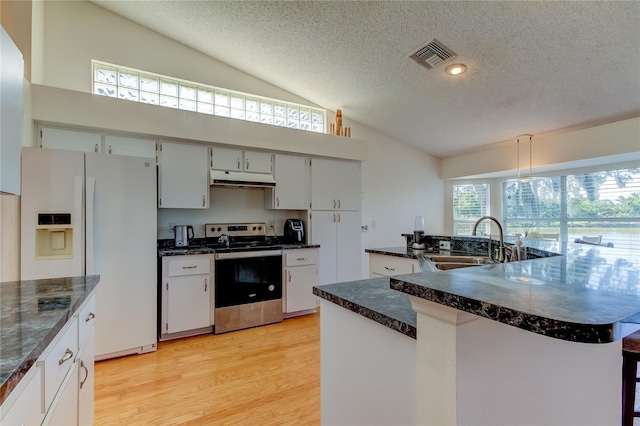 kitchen featuring white fridge with ice dispenser, a kitchen island with sink, stainless steel electric range oven, a textured ceiling, and sink