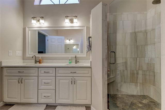 bathroom featuring a shower with door and vanity