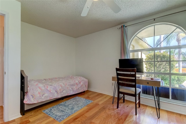 bedroom featuring ceiling fan, a textured ceiling, and wood-type flooring