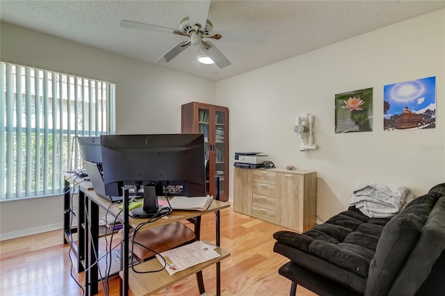 office area with a textured ceiling, ceiling fan, light hardwood / wood-style flooring, and plenty of natural light