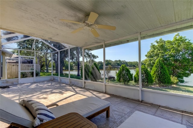 unfurnished sunroom featuring ceiling fan, a wealth of natural light, and a water view