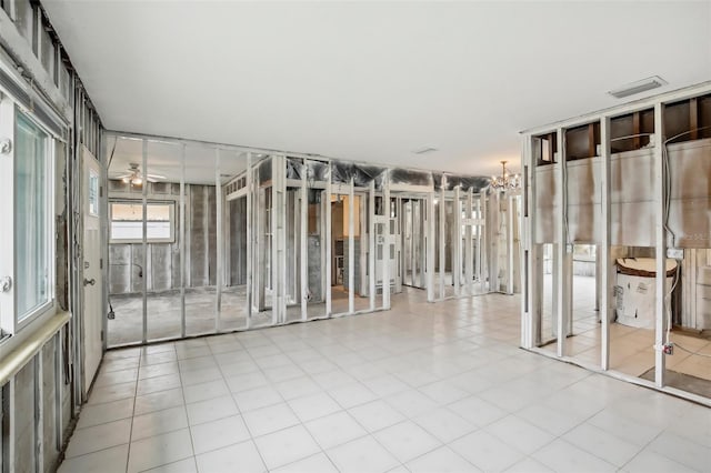 interior space featuring tile patterned flooring and ceiling fan with notable chandelier