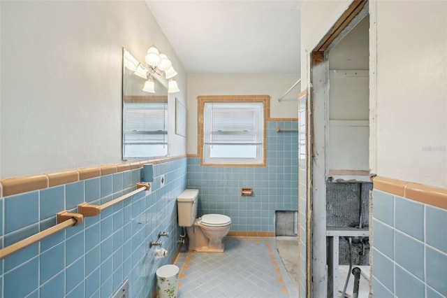 bathroom with tile patterned flooring, tile walls, and toilet