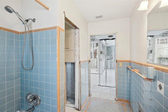 bathroom with tile patterned flooring and tile walls