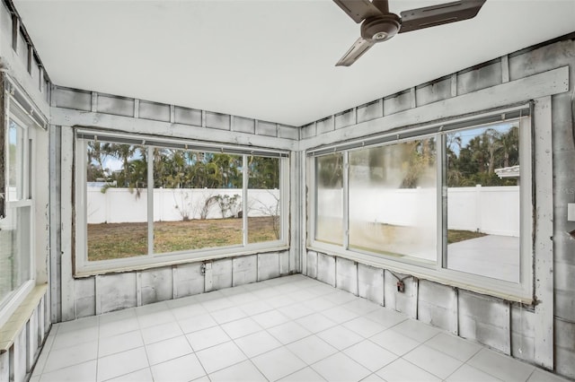 unfurnished sunroom featuring ceiling fan