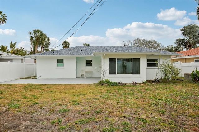 rear view of house featuring a lawn and a patio area