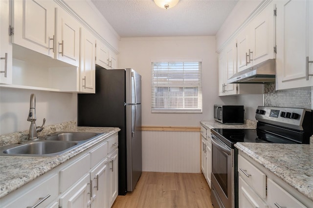 kitchen with stainless steel appliances, sink, white cabinets, a textured ceiling, and light wood-type flooring