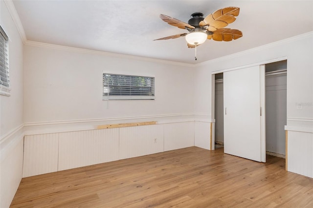 unfurnished bedroom with ceiling fan, light hardwood / wood-style floors, crown molding, and a closet