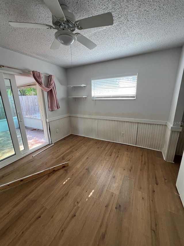 empty room featuring a textured ceiling, hardwood / wood-style floors, and ceiling fan