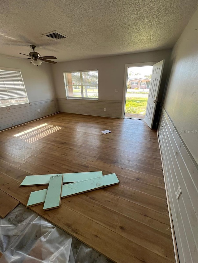 empty room with a textured ceiling and ceiling fan