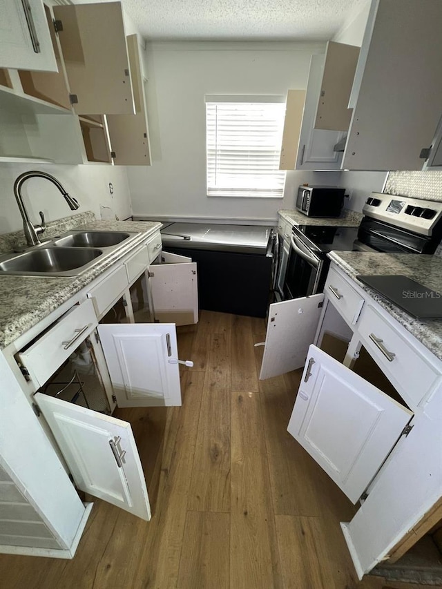 kitchen with stainless steel appliances, sink, white cabinetry, a textured ceiling, and dark hardwood / wood-style flooring