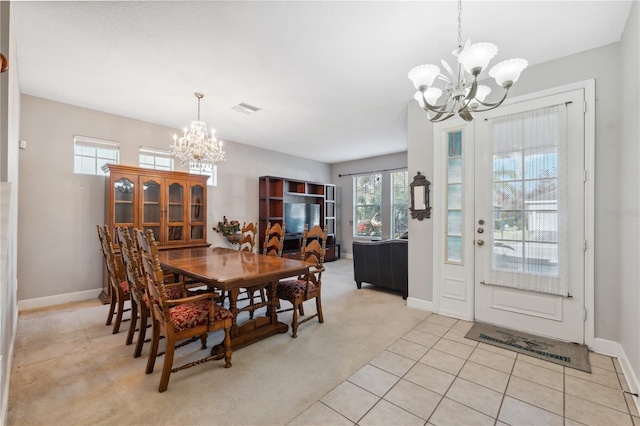 dining area with light colored carpet and a notable chandelier