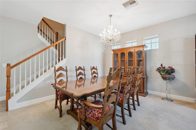 carpeted dining room featuring an inviting chandelier