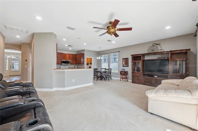 carpeted living room featuring ceiling fan and sink