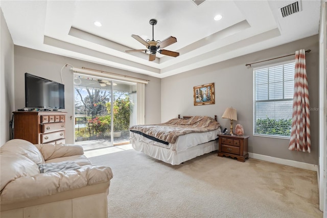 bedroom featuring ceiling fan, access to exterior, and a raised ceiling