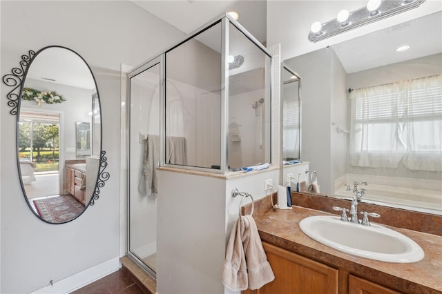 bathroom featuring shower with separate bathtub, tile patterned floors, and vanity