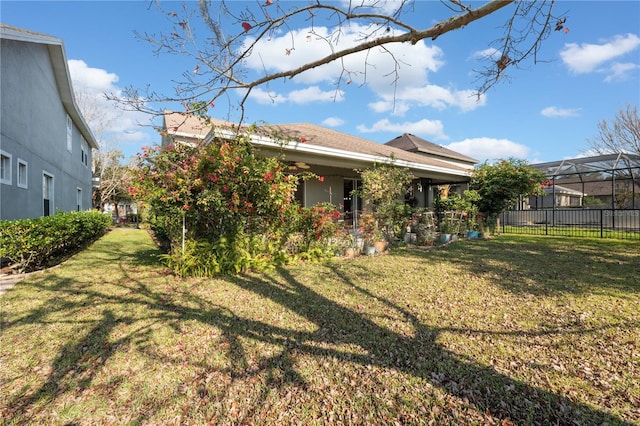 rear view of house featuring a lawn and a lanai