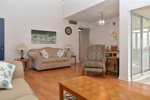 living room with hardwood / wood-style flooring and an inviting chandelier