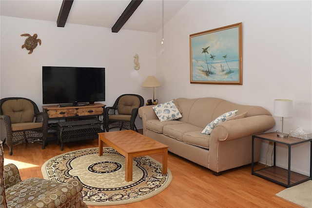 living room featuring lofted ceiling with beams and light hardwood / wood-style flooring