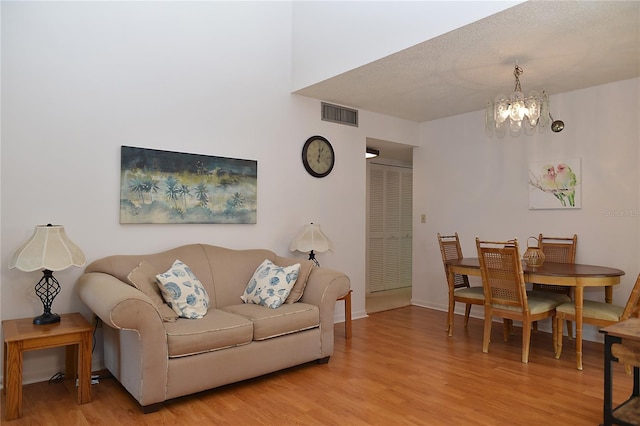 living room featuring a chandelier and light hardwood / wood-style flooring