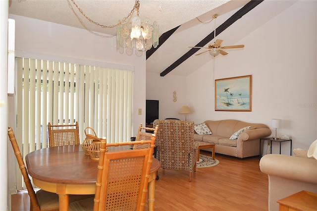 dining area with hardwood / wood-style floors, ceiling fan with notable chandelier, and vaulted ceiling with beams