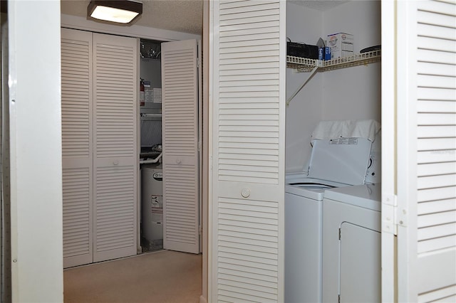 laundry area with washer and clothes dryer, water heater, and a textured ceiling