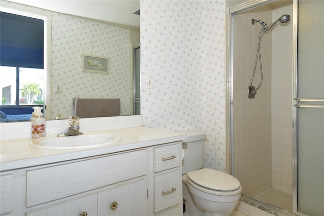 bathroom featuring toilet, a shower with door, and vanity