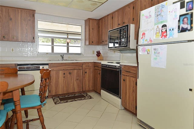 kitchen featuring electric stove, backsplash, dishwasher, sink, and white refrigerator