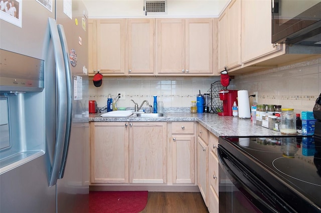 kitchen with sink, light brown cabinetry, and black appliances