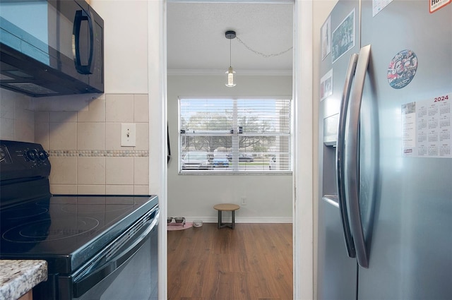 kitchen with decorative light fixtures, wood-type flooring, backsplash, black appliances, and crown molding