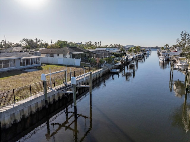 dock area with a lawn and a water view